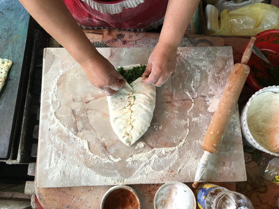 Zhingyalov hats, a flatbread stuffed with finely diced herbs and greens, being prepared. It is a traditional dish of Armenians of Artsakh and Syunik. (Photo: Souren Papazian)