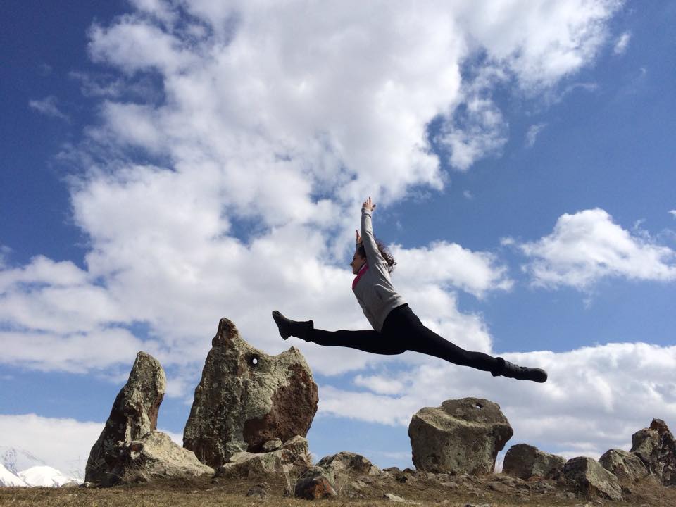 Volunteer Armina Khachatryan leaps across the monoliths at Carahunge. (Photo: Surench Photography, 2015)