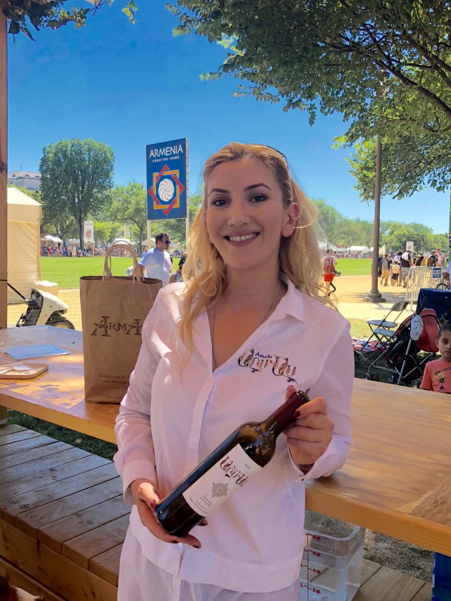 The CEO of ArmAs Winery, Victoria Aslanian, poses in full ArmAs gear at the Smithsonian Folklife Festival.