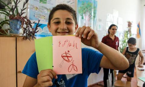 In addition to academic topics, HRI volunteers also instruct on various issues related to health and wellness. In this image from a 2017 summer camp session, a student from the village of Shvanidzor holds up a sign that says չծխել (Do not smoke).