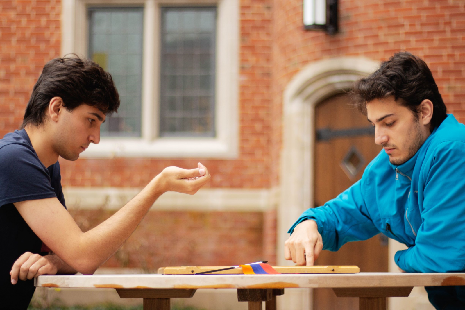 ​​​​Brothers Artin and Arthur Kasumyan, both students at Yale, play a game of backgammon (or Nardi) outside of their student housing building. (Photo: Nune Garipian)
