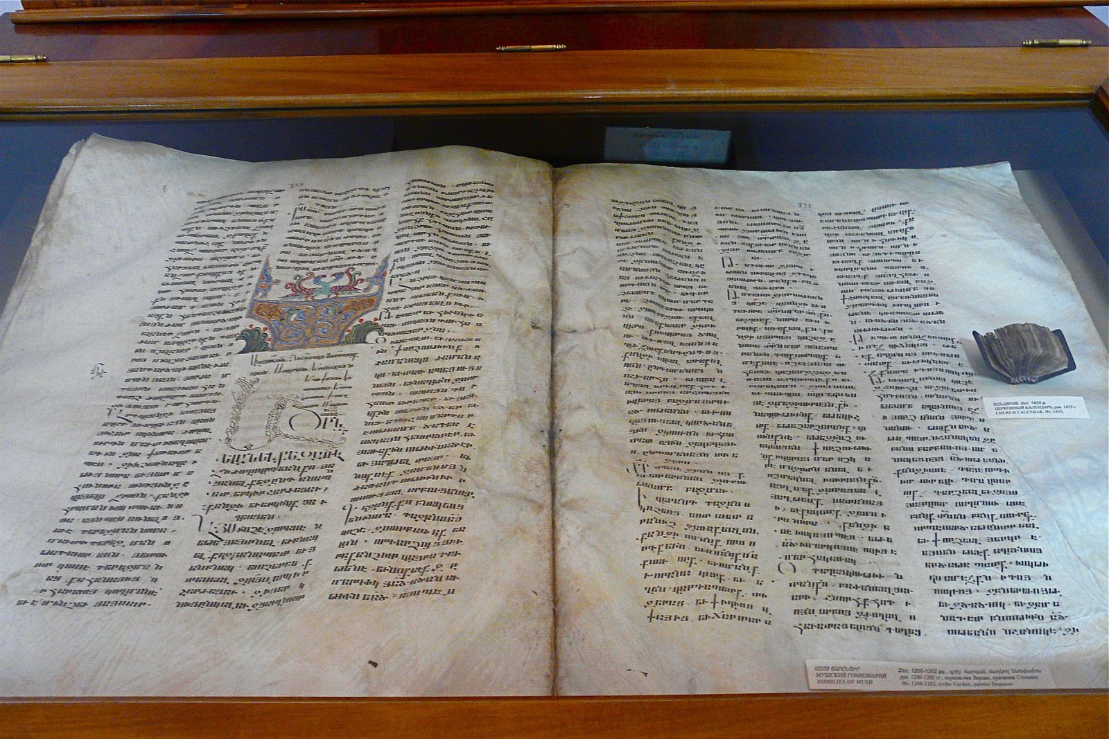 the giant manuscript, displays it next to its smallest counterpart,